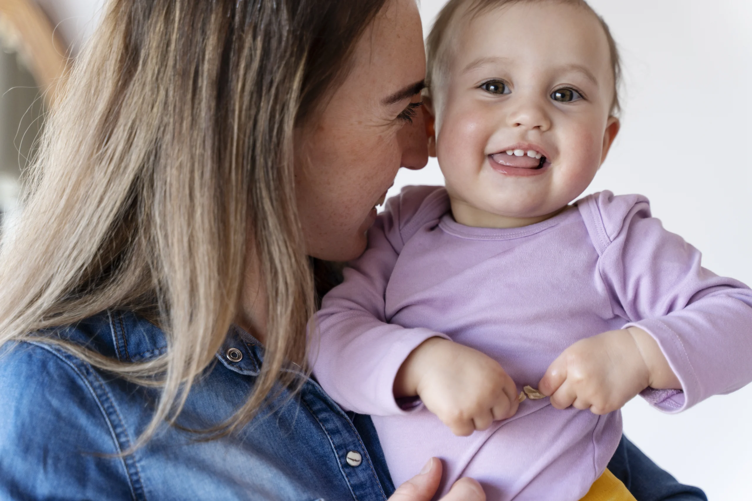 madre sosteniendo a su bebé sonriendo